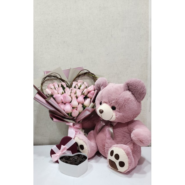 Oso con ramo de flores en forma de corazón con caja de chocolates